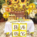Party setup with 'BABY' balloons, sunflower balloons, star balloons, and confetti balloons, plus decorated blocks spelling 'BABY'.