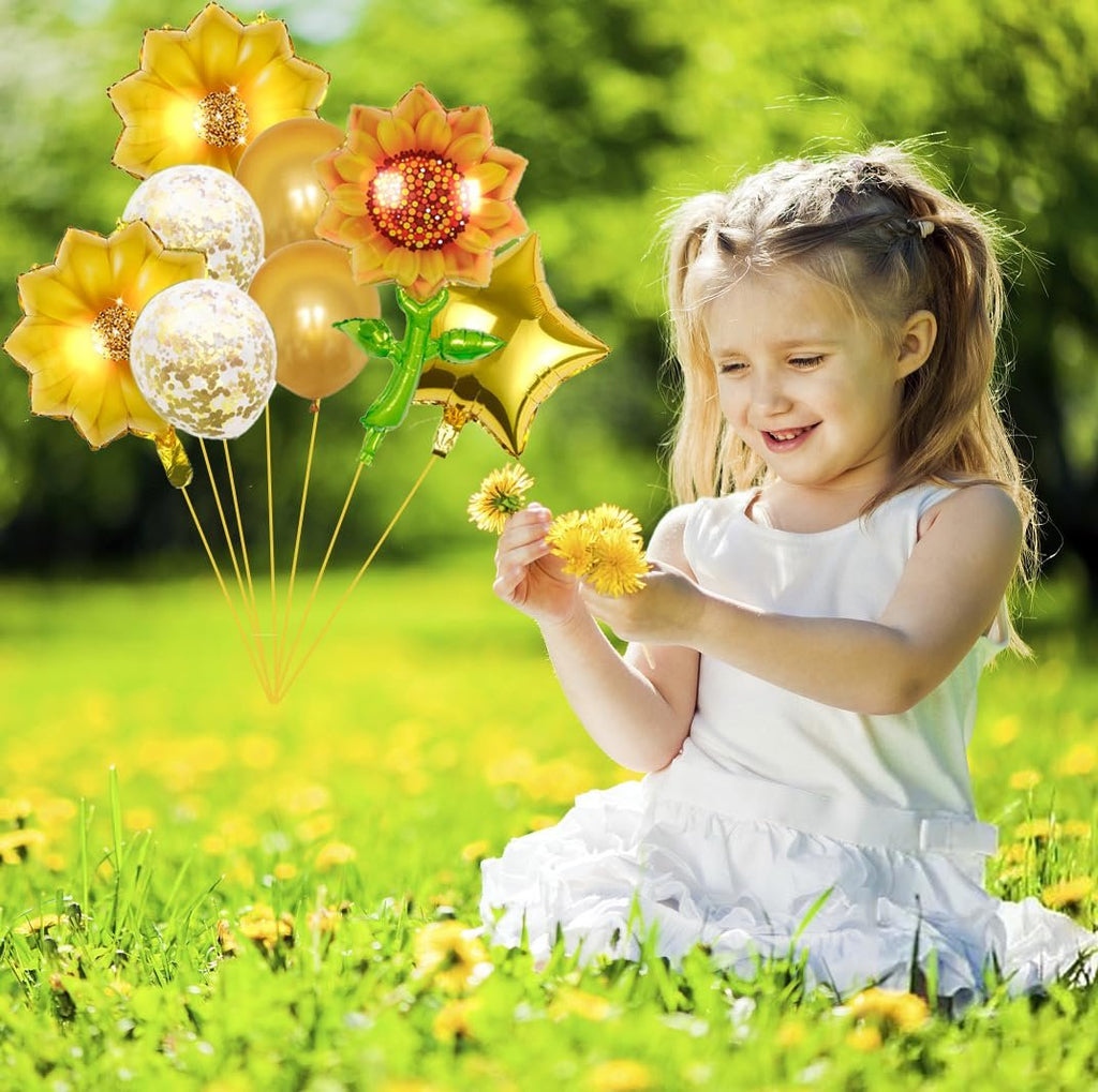 Young girl in a white dress holding dandelions in a field of yellow flowers with a bouquet of sunflower and star balloons