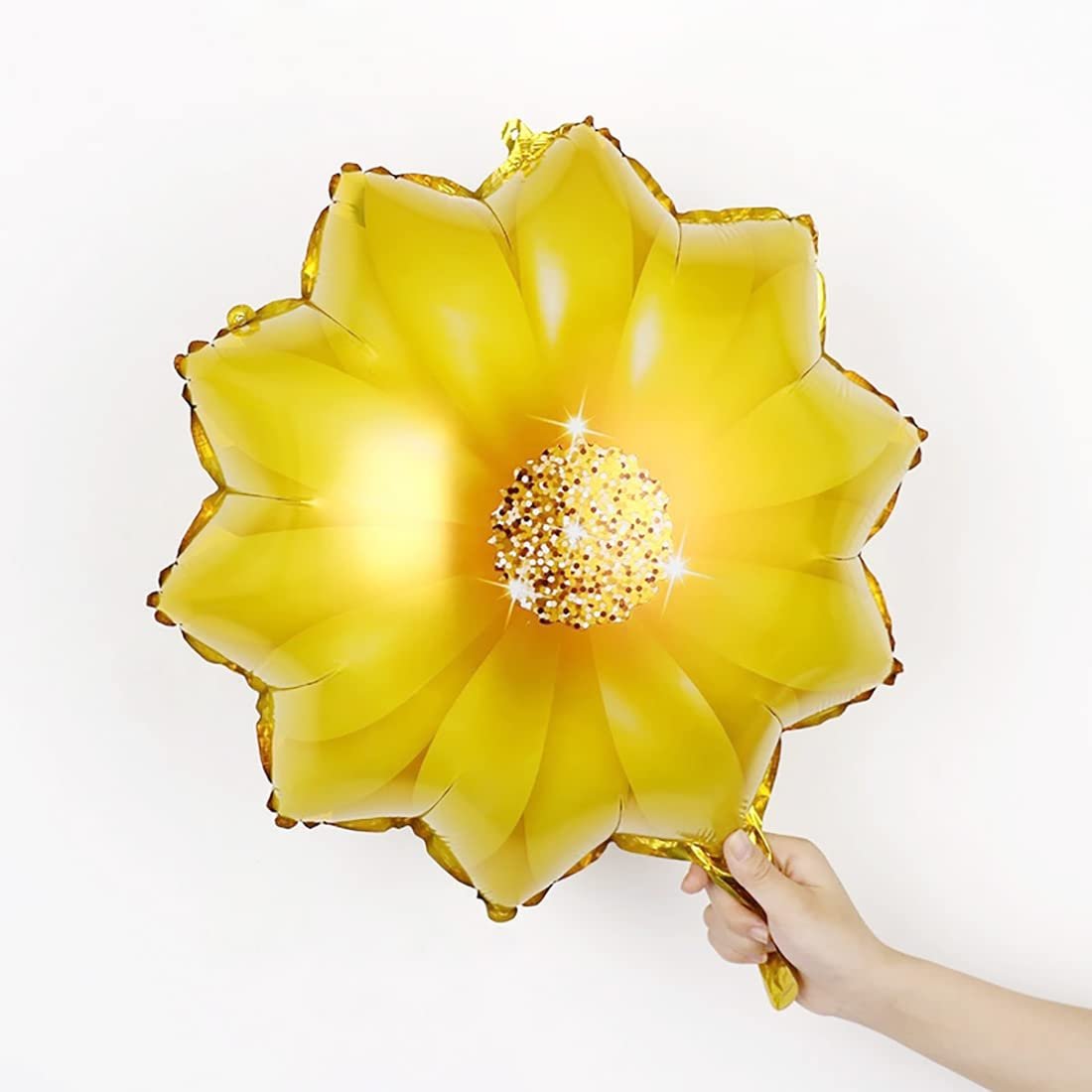 Yellow sunflower foil balloon held by a hand against a white background, featuring a glittery center and sparkling effects.
