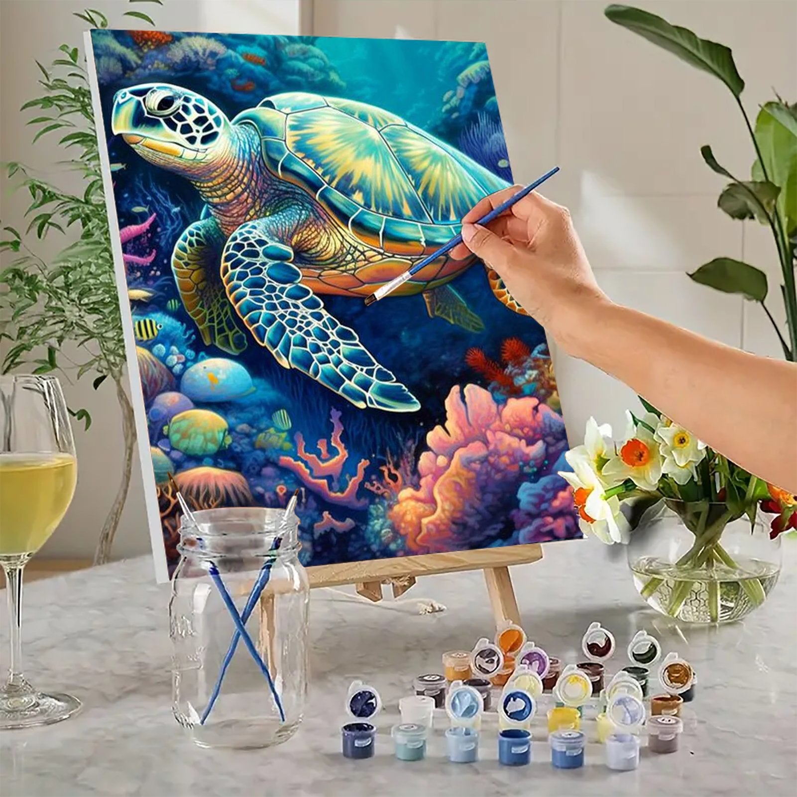 Hand painting a sea turtle on canvas with acrylic paints and brushes on an easel