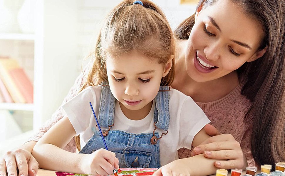 Mother and daughter painting a sea turtle picture together at a table.