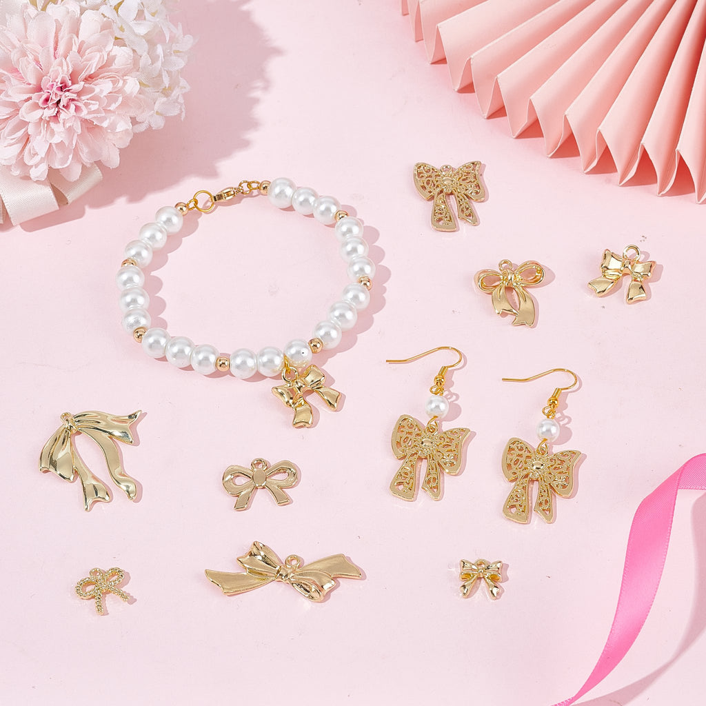 Gold tone bow charms and a pearl bracelet with bow charm on pink background
