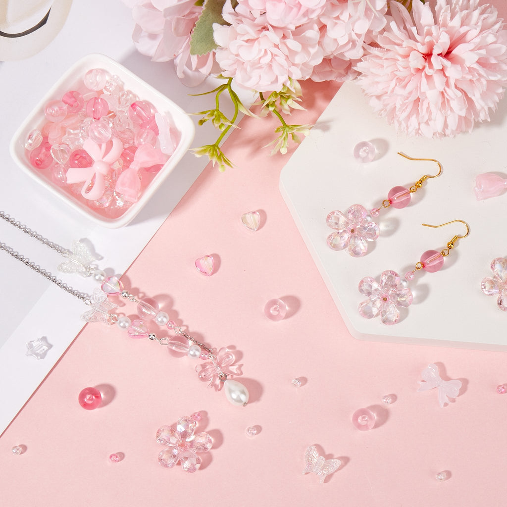Pink enamel bow charms and flower charms with beads arranged for jewelry making