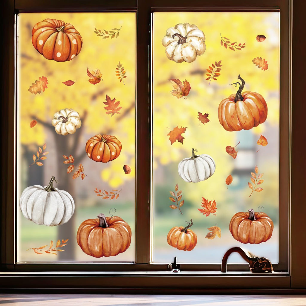 Autumn pumpkin and leaf window clings applied to a window with a blurred yellow tree background.