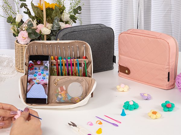 Crochet hook set case open showing hooks, accessories, and a phone displaying a crochet tutorial, with hands crocheting in foreground.