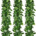 Three strands of artificial vine garland with green fabric leaves against a white background.