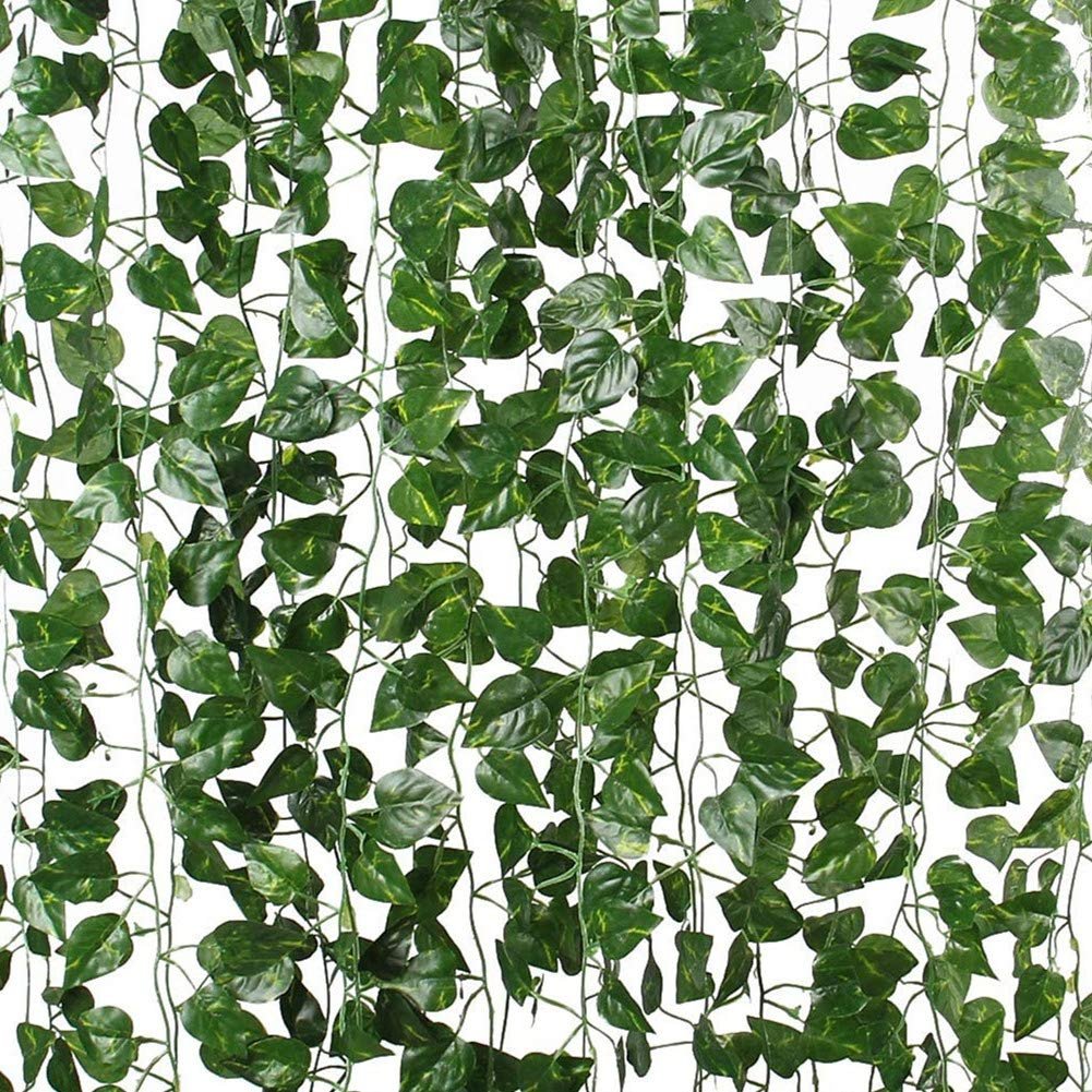 Artificial vine garland with green fabric leaves hanging against a white background.