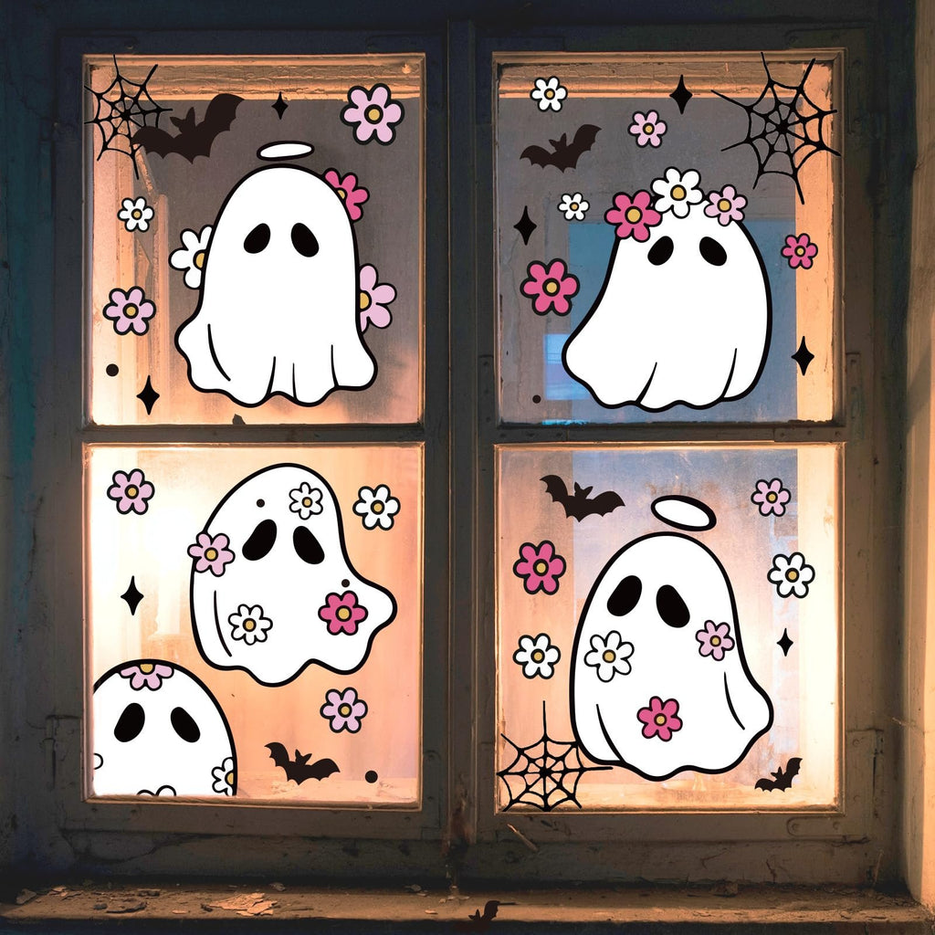 Halloween window clings featuring cute ghosts with flowers, bats, and spiderwebs applied to a window pane.