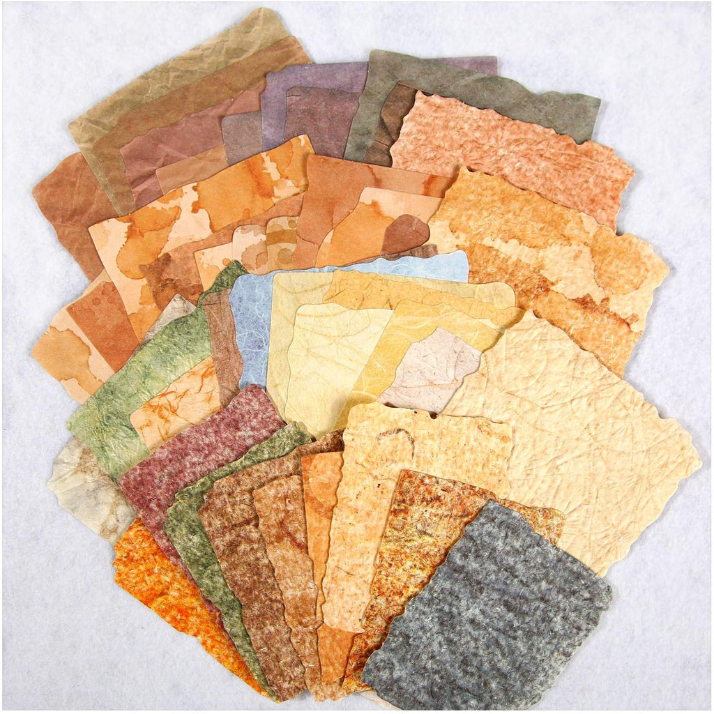 Assortment of textured, deckled-edge scrapbook papers in various vintage earth tones, fanned out on a white background.