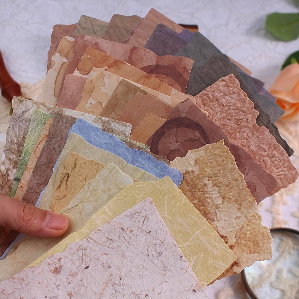Hand holding a fan of textured scrapbook paper in various vintage colors and deckled edges.