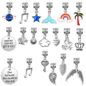 Collection of 18 assorted charms for bracelet making, including planets, musical notes, stars, tails, rainbows, palm trees, shells, clouds, hearts, swans, crowns, keys, leaves, and wings.