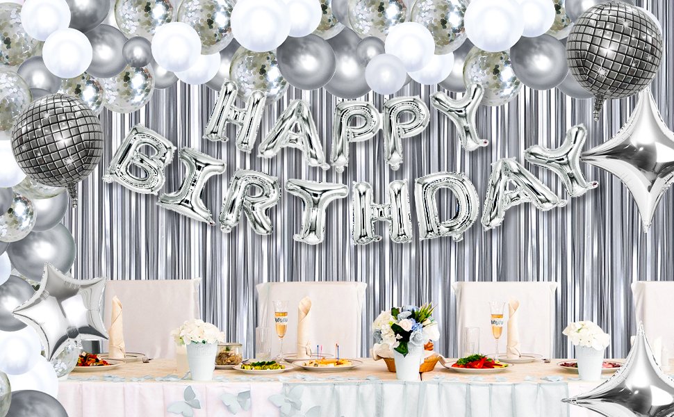 Silver and white balloons spelling HAPPY BIRTHDAY above a decorated table setting with foil disco ball balloons.