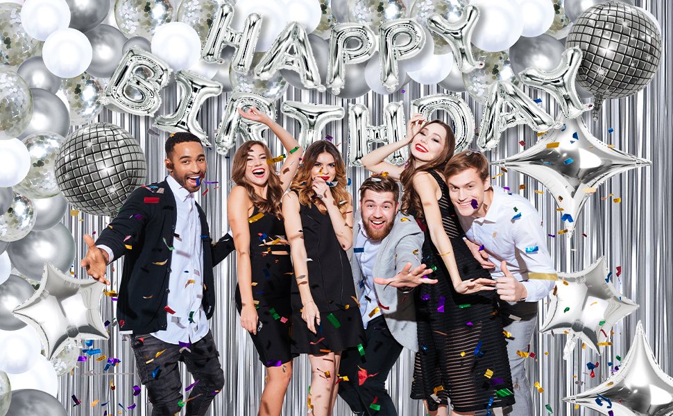 Group of young adults celebrating with silver and white balloons and disco balls