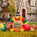 Inflatable Thanksgiving turkey with vegetables and 'Happy Thanksgiving' text, set up on a lawn in front of a stone building.
