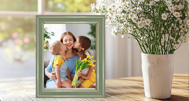 Rustic farmhouse picture frame displaying a mother and her two children, with white flowers in a vase nearby.