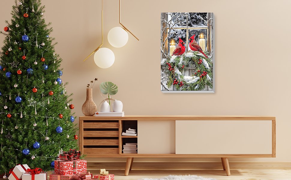 Framed winter cardinal and wreath painting displayed above a wooden credenza next to a decorated Christmas tree.