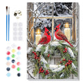 Paint by numbers kit showing two cardinals on a snowy wreath in front of a window with lit candles, includes brushes, paint pots, and hanging hardware.