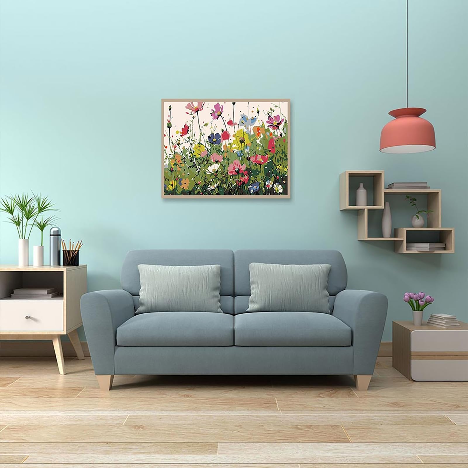 Framed paint by numbers kit with colorful wildflowers hanging on a light blue wall above a sofa.