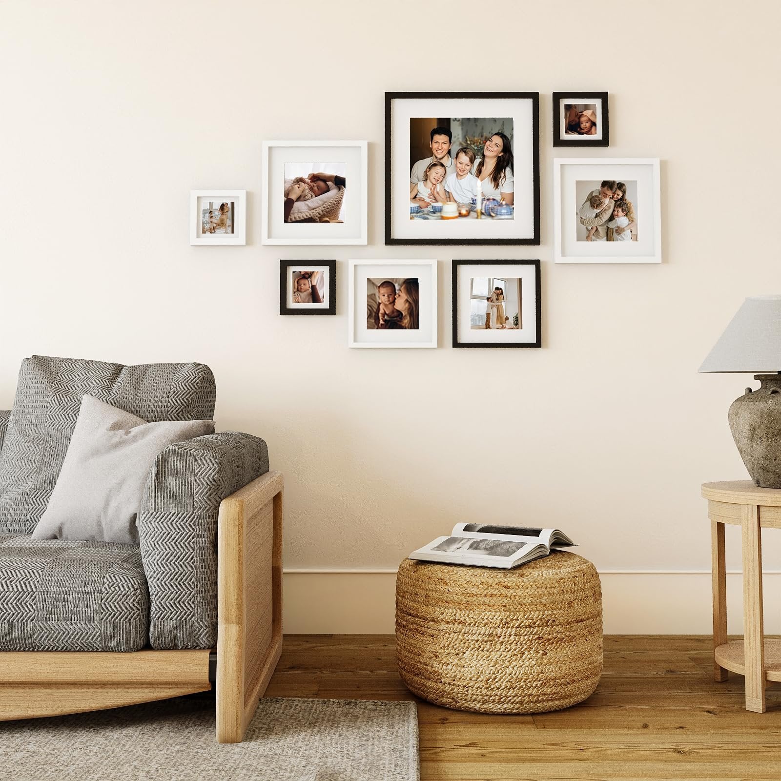 Gallery wall of seven framed photos above a sofa and ottoman, with a side table and lamp.