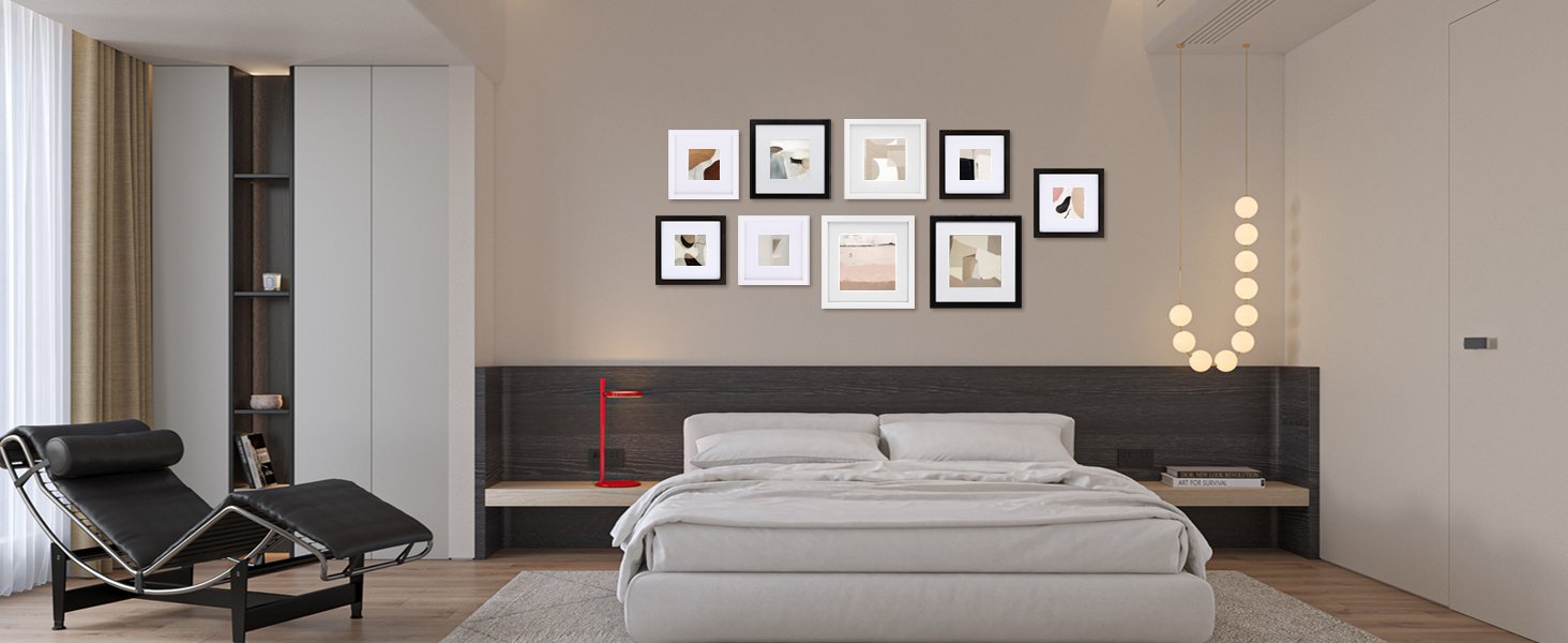 Bedroom scene with a wall of seven framed abstract art prints above a bed, a chaise lounge, and a nightstand.