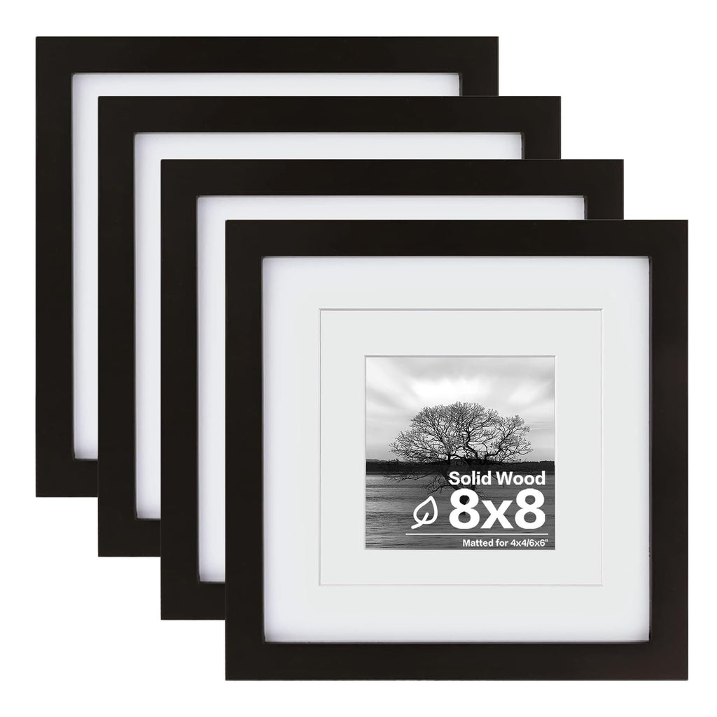 Set of four black solid wood picture frames with white mats, one frame shows a landscape photo with text.