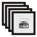 Set of four black solid wood picture frames with white mats, one frame shows a landscape photo with text.