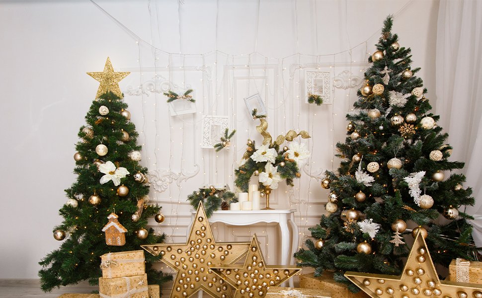 Two decorated Christmas trees with a gold 5-point star tree topper on the left tree, surrounded by gifts and decorative stars.
