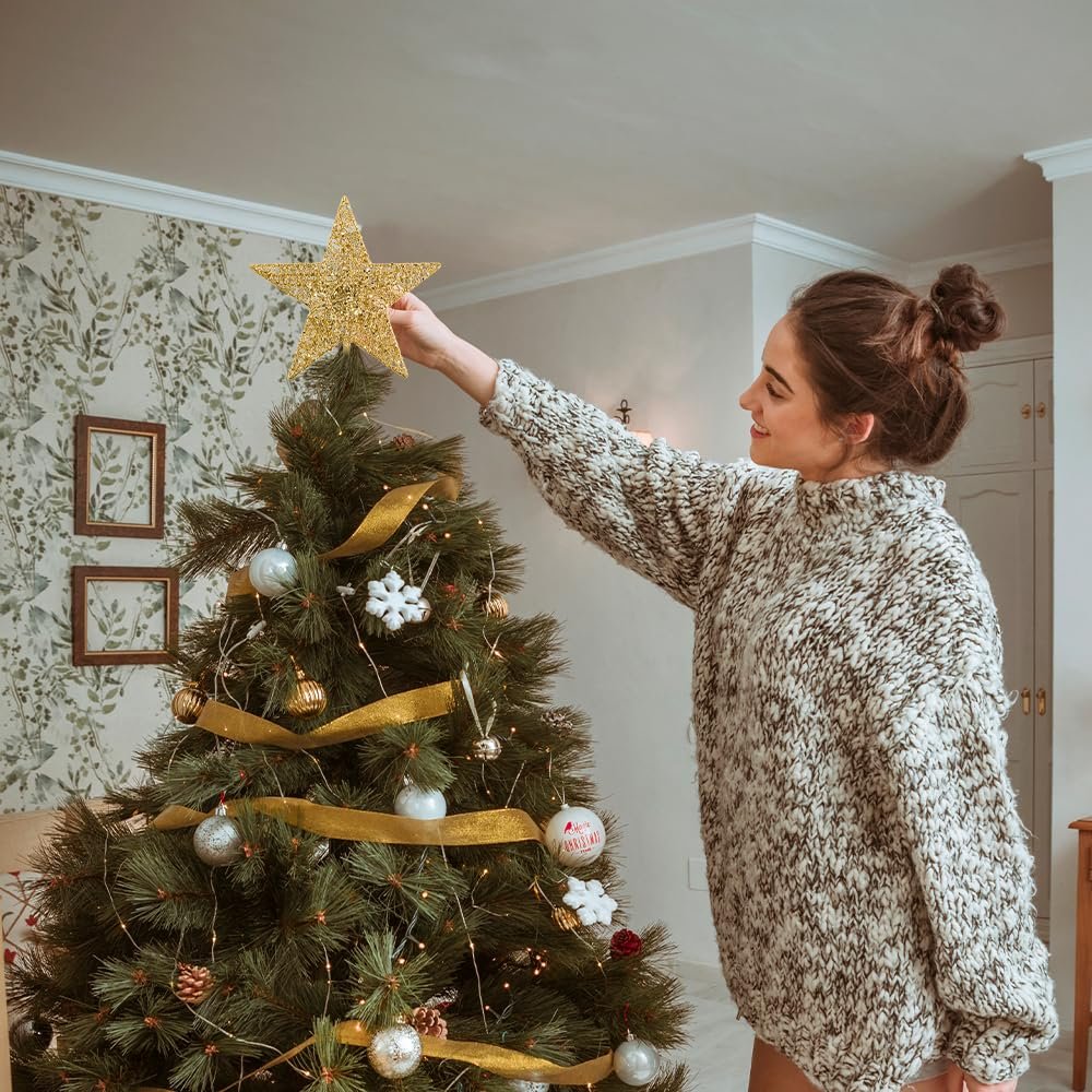 Woman placing a gold glittery 5-point star tree topper on a decorated Christmas tree