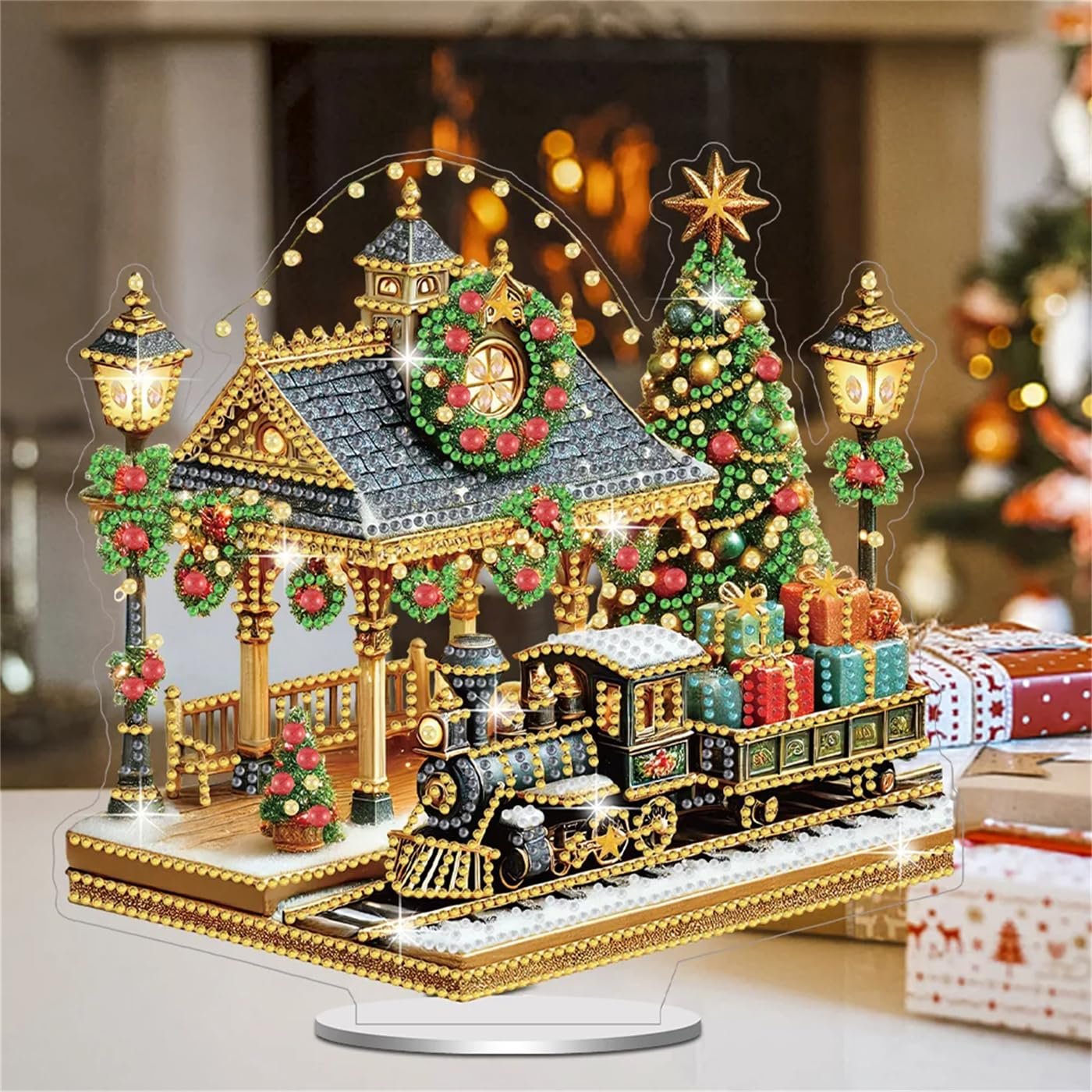 Diamond art painting kit of a Christmas railway station with a train, tree, and lampposts, displayed on a table.