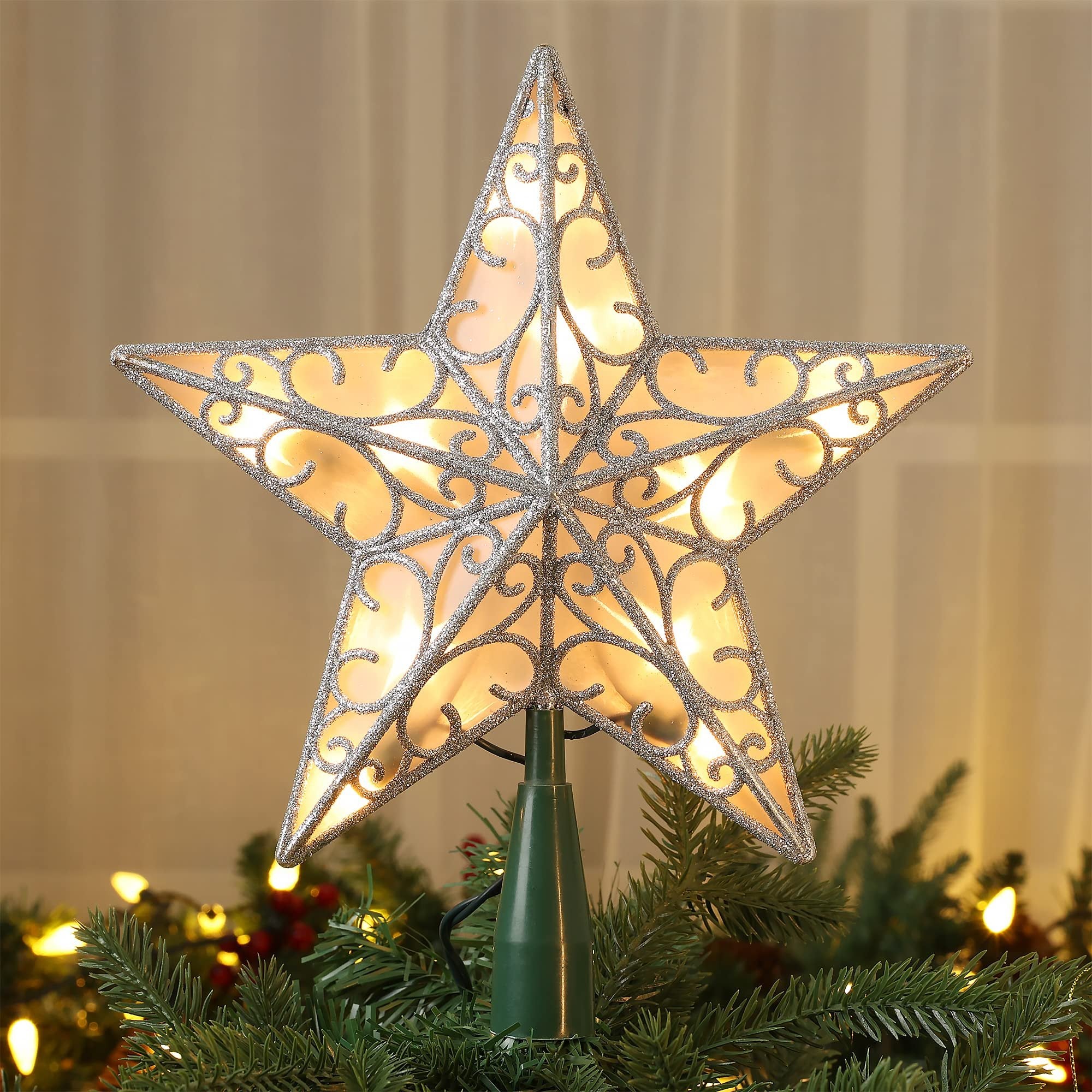 Illuminated 3D star tree topper with silver glitter filigree, placed on a Christmas tree.
