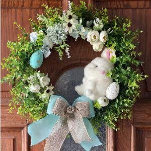 Easter wreath with artificial boxwood greenery, white bunny, blue eggs, and a light blue bow on a wooden door.