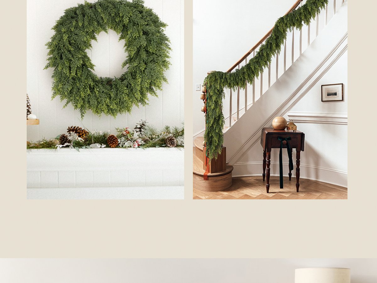 Green cedar garland draped along a staircase railing and a wreath on a mantelpiece with pinecones and festive decor.