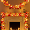 Fall maple leaf garland with warm orange lights draped over a fireplace mantel and wall