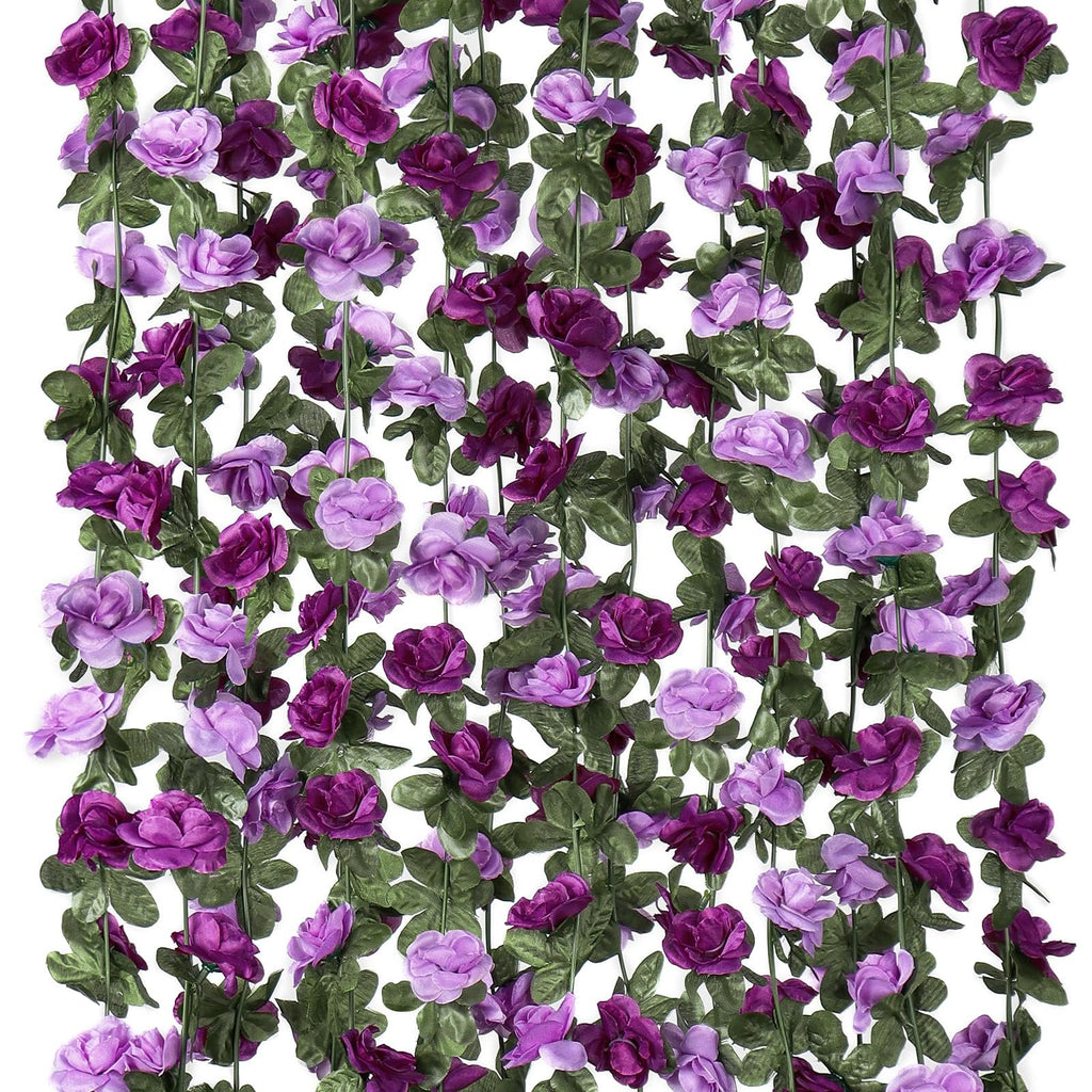 Artificial purple rose garland with green leaves hanging vertically against a white background.