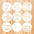 Nine round stencils with various welcome-themed phrases and designs, arranged on a wooden background.