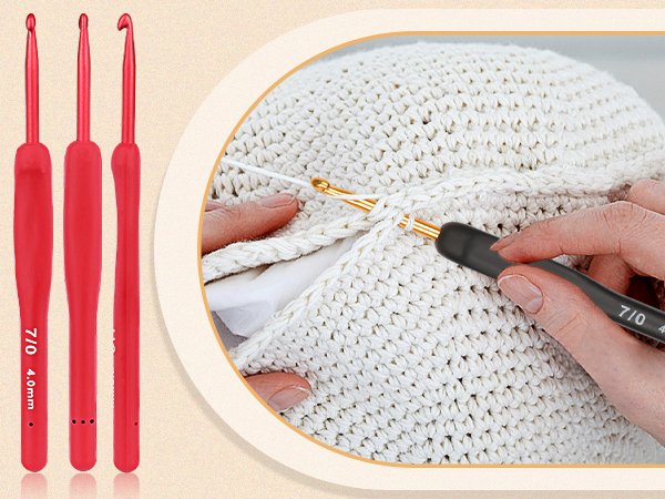 Close-up of red and black crochet hooks with ergonomic grips, one in use on white fabric.
