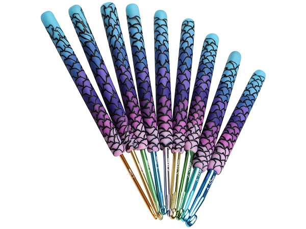 Set of 9 ergonomic crochet hooks with colorful ombre dragon scale pattern handles and metal tips, angled view on white background.