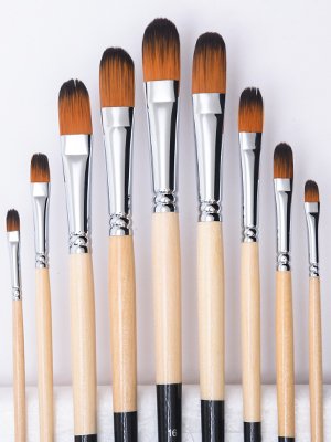 Nine filbert paint brushes with synthetic nylon hair and long wooden handles arranged in a row.