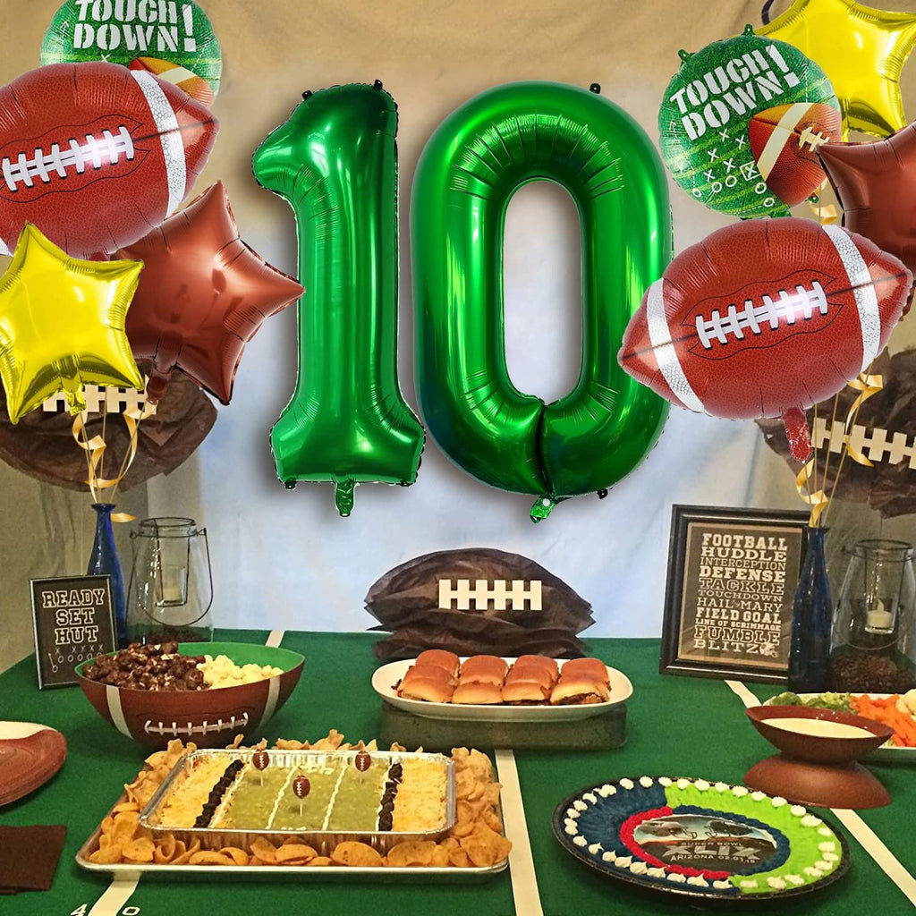 Football themed party setup with green tablecloth, football balloons, number 10 balloons, and party food.