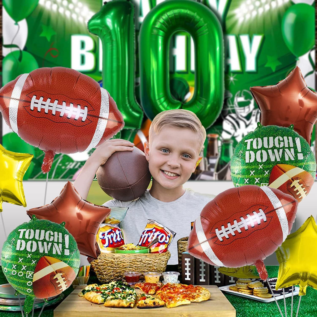 Boy holding a football with a football-themed balloon set including number 10 balloons and field balloons