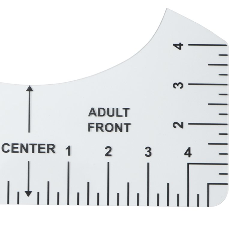 Close-up of a clear plastic t-shirt ruler alignment tool showing measurements and markings for centering designs.