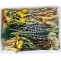 Assortment of dried flowers including lavender, yellow roses, wheat, and bunny tails in a basket.