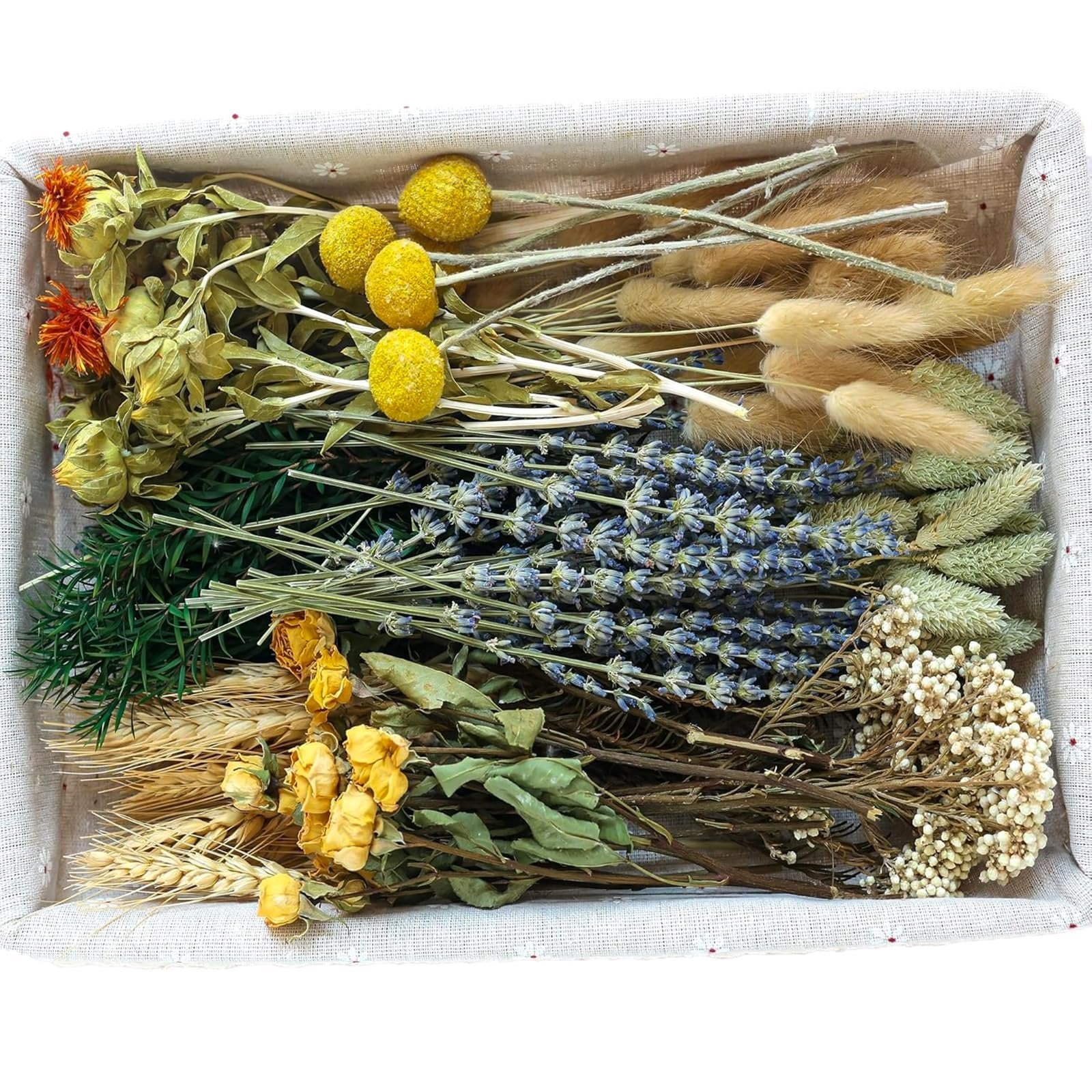 Assortment of dried flowers including lavender, yellow roses, wheat, and bunny tails in a basket.
