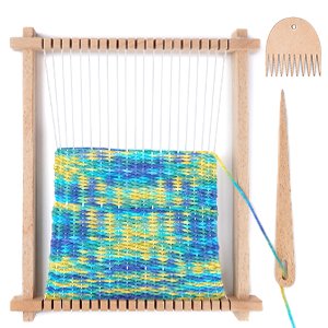 Wooden weaving loom kit with partially woven colorful yarn, shuttle bar, and comb on white background