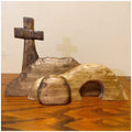 Wooden Easter tomb scene with cross and rolling stone on a wooden surface