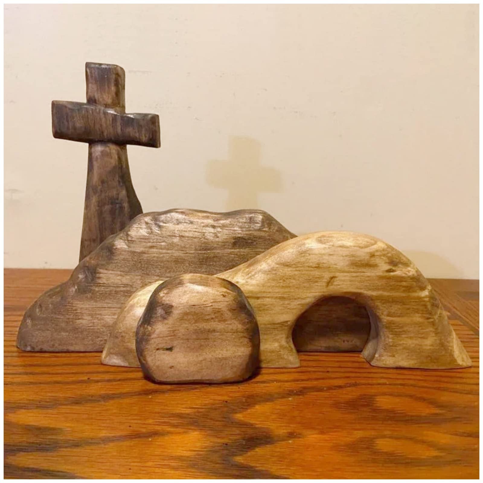 Wooden Easter tomb scene with cross and rolling stone on a wooden surface