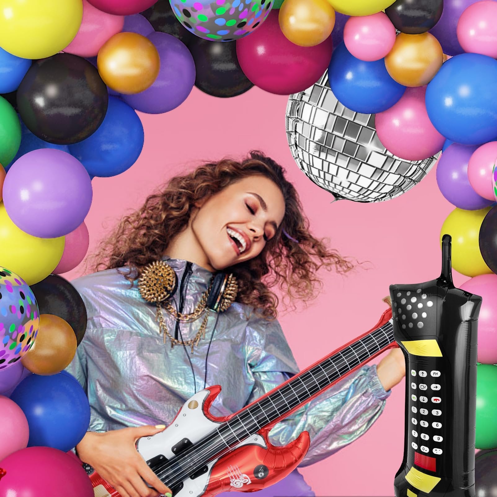 Woman playing guitar with 80s/90s themed balloons, disco ball, and retro phone.
