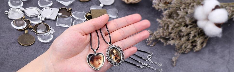 Hand holding two finished pendants with images inside, surrounded by blank pendant trays and glass cabochons.