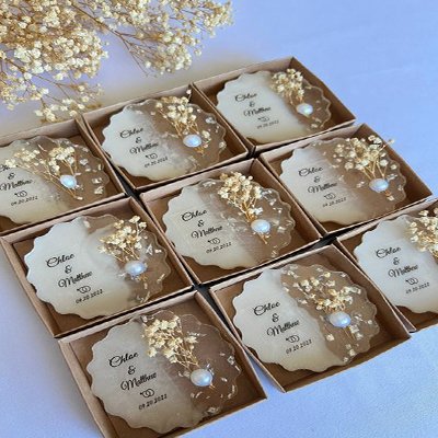 Set of nine decorative resin coasters with dried baby's breath flowers and pearls, each personalized with names and a date.