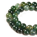 Strand of 4mm round moss agate gemstone spacer beads for jewelry making, close-up view on white background.